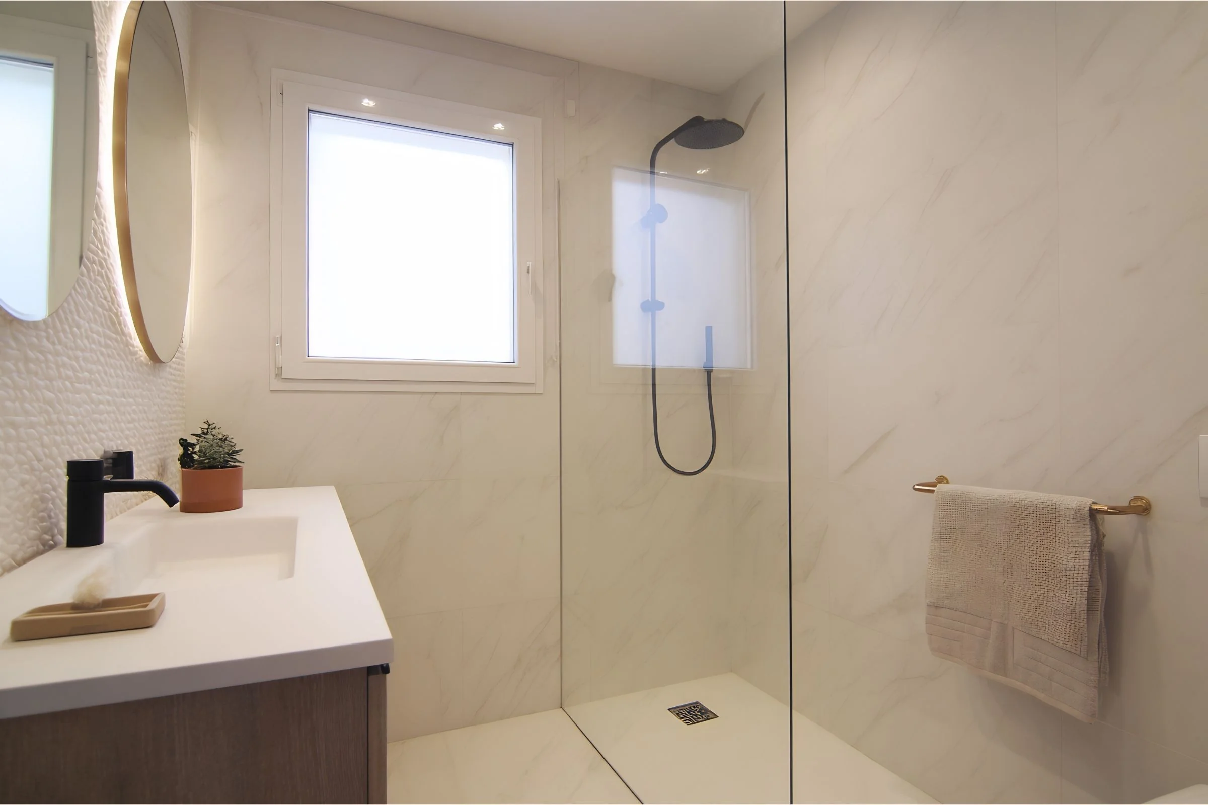 Reforma de baño en Alicante — plato de ducha extraplano, grifería negra mate, mármol porcelánico y espejo LED